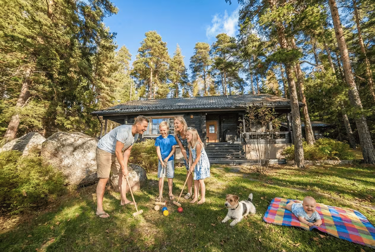 Perhe pelaamassa krokettia Skitunäsin mökillä Pyhtäällä. Ihana perhemökki lähellä Helsinkiä