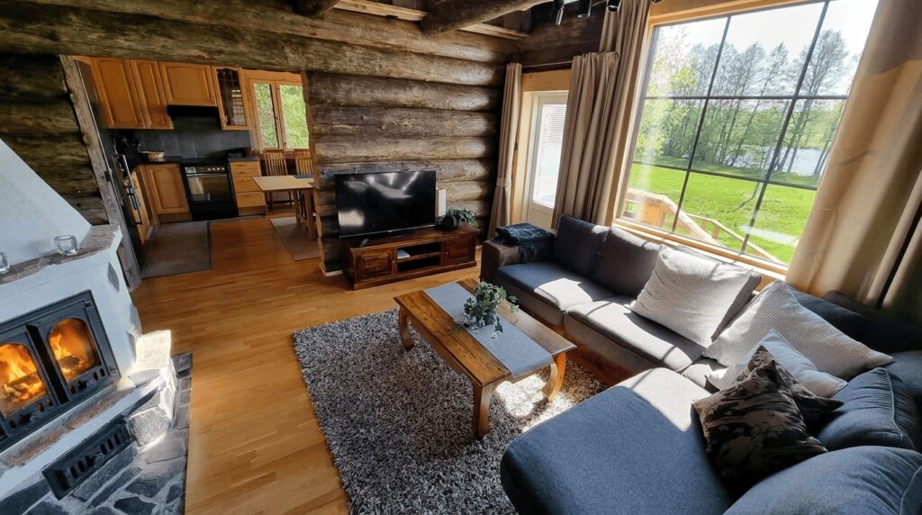 Villa Kaunisvirta Pyhtäällä. Olohuoneessa takka ja upeat näköalat joelle