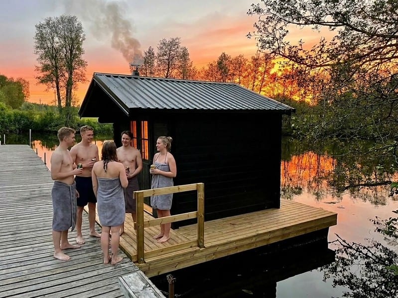 Kaveriporukka vilvoittelemassa kaunisvirran lauttasaunan edustalla